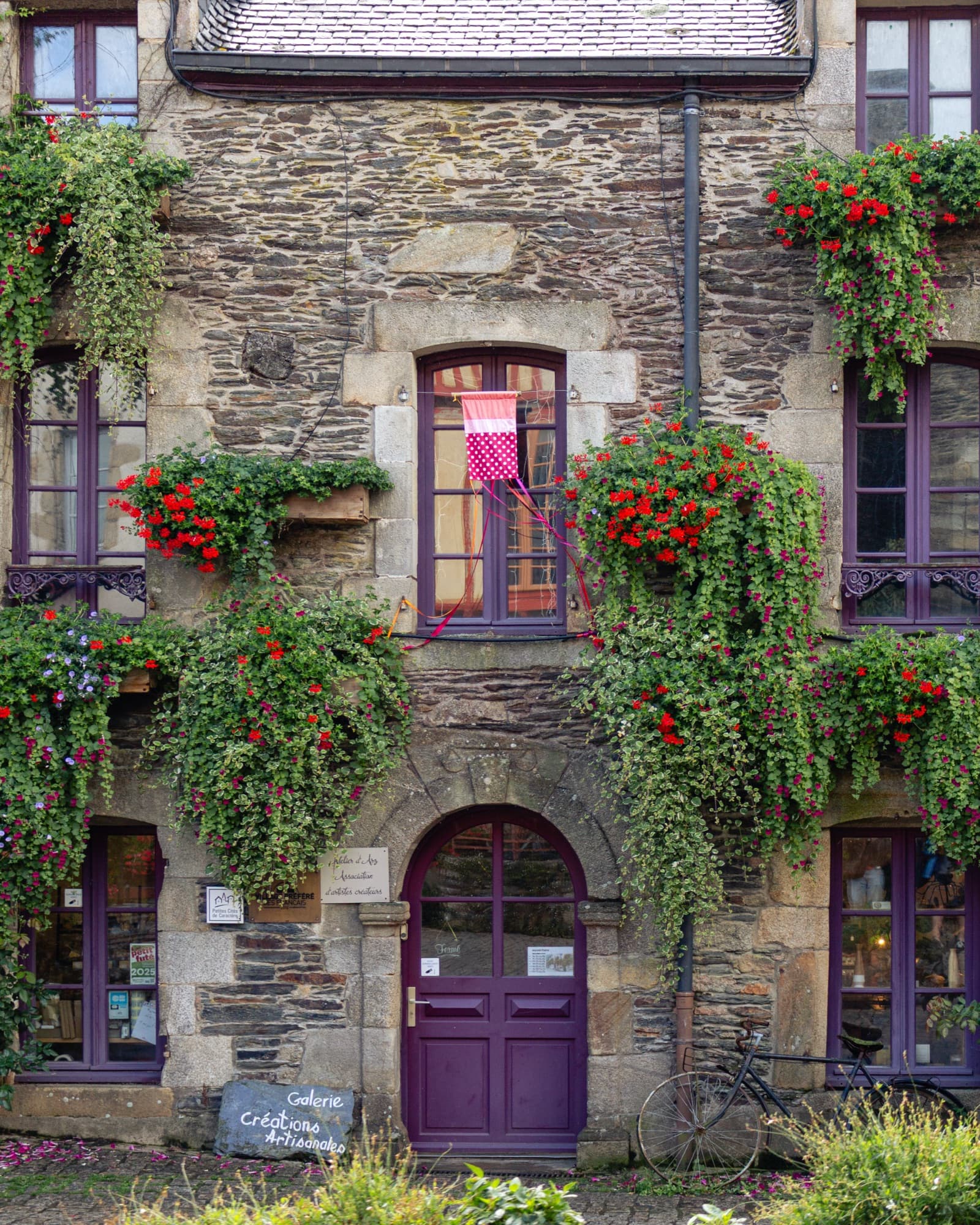 Stone façade with flower boxes and a purple door