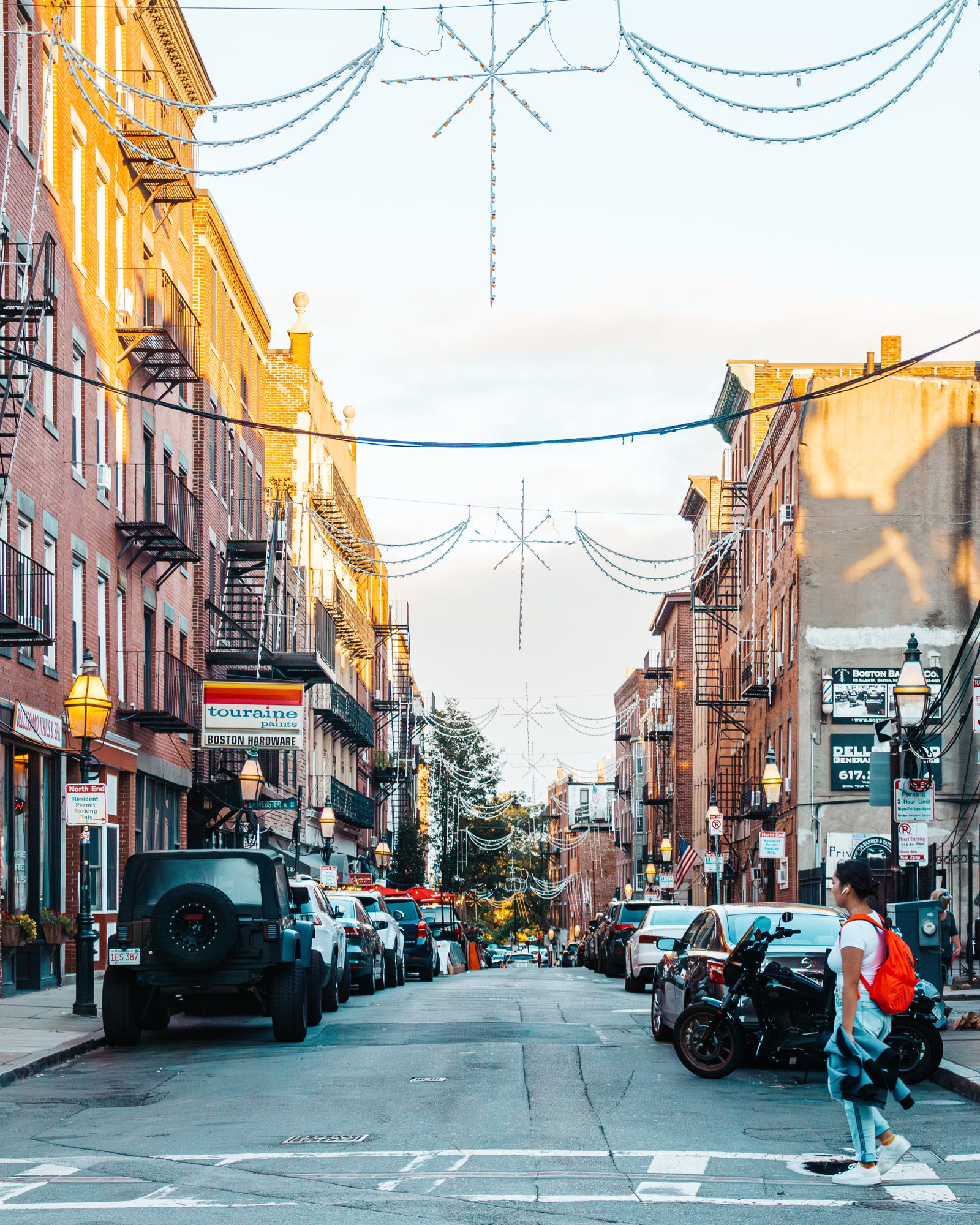 Street decorated with lights between brick buildings