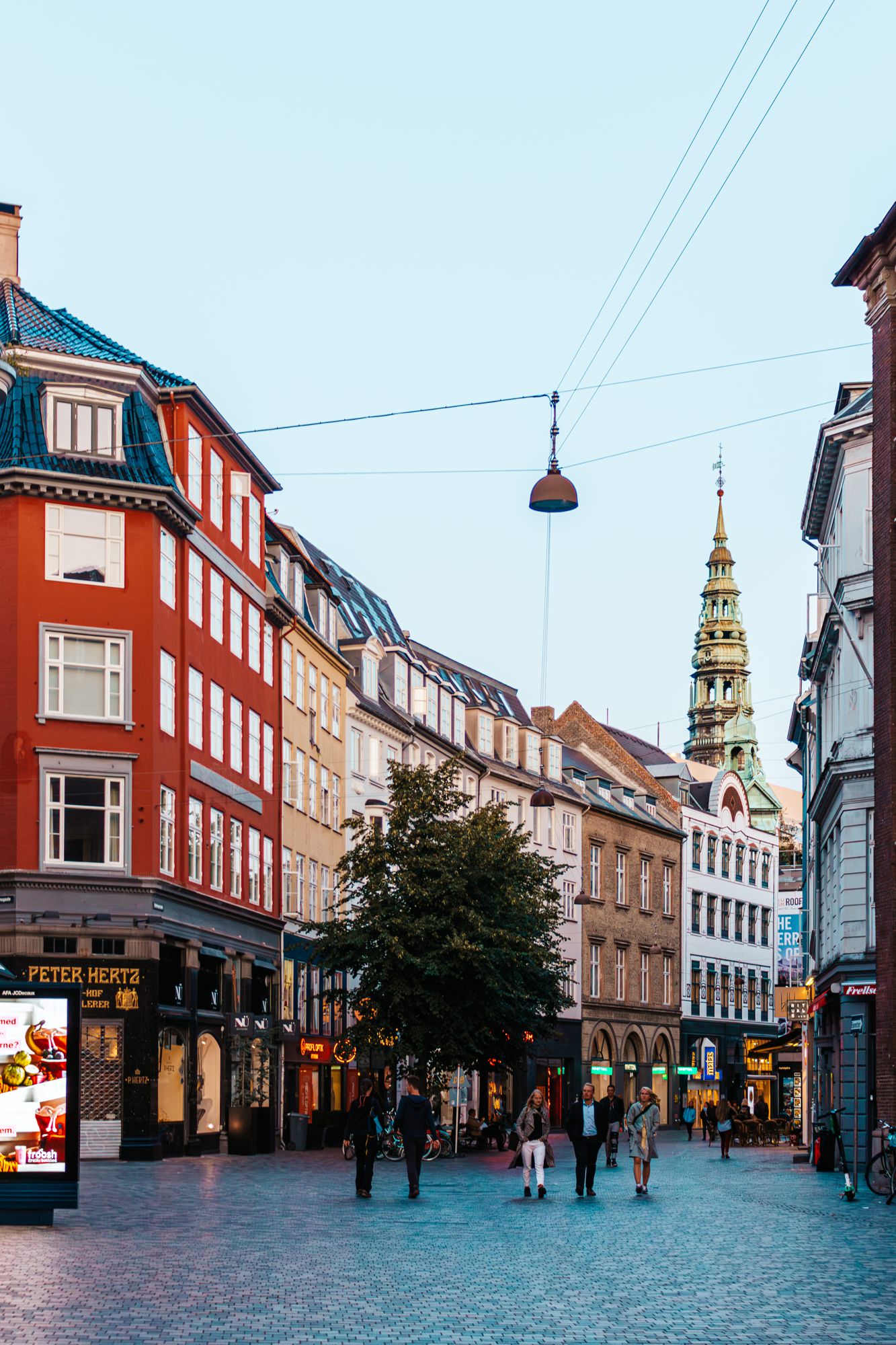 Busy pedestrian street with a spire